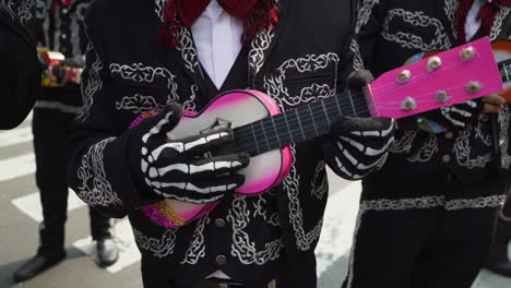 Hombre-Con-Traje-De-Mariachi-Y-Máscara-De-Calavera-Toca-Un-Ukelele-En-Las-Celebraciones-Anuales-Del-Desfile-Del-Día-De-Los-Muertos-En-La-Ciudad-De-México