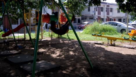 Kleiner-Junge-Genießt-Die-Schaukel-Auf-Einem-Spielplatz-In-Einem-Wohnviertel-In-Mandaue-City,-Philippinen