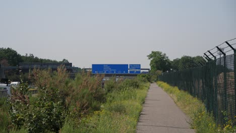 Eine-Aufnahme-Des-Verkehrsaufkommens-An-Der-Autobahn-A5-Unterhalb-Der-Beschilderung-Zeigt-Die-Richtung-Zum-Flughafen-Cargocity-Süd-In-Frankfurt,-Deutschland