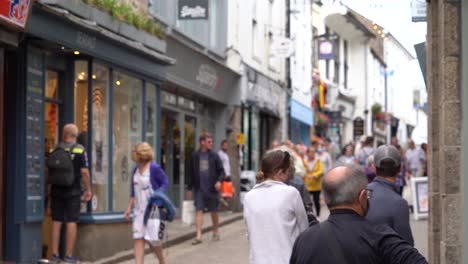 People-enjoying-some-shopping-along-a-side-street-in-St-Ives,-Cornwall,-UK