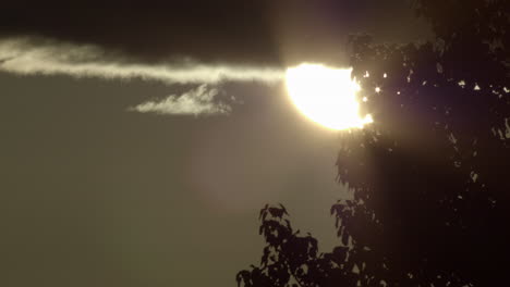 Luz-Solar-Vibrante-Detrás-De-Las-Nubes-Con-Siluetas-De-árboles-Frondosos