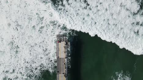 Large-waves-breaking-under-a-concrete-walking-platform-built-out-to-the-ocean