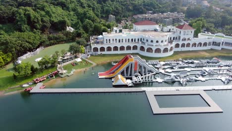 People-enjoying-a-sunny-day-at-Hong-Kong-core-aqua-park-floating-fun-slides,-Aerial-view