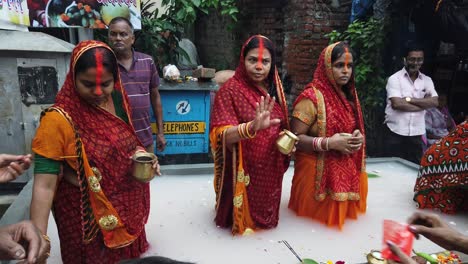 Blick-Auf-Die-Indischen-Frauen,-Die-Während-Der-Chatt-Puja-Auf-Der-Straße-Von-Kalkutta-Im-Wasser-Stehen