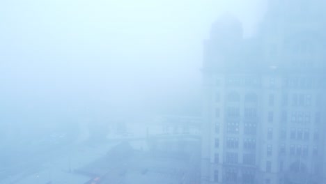 Thick-dense-ghostly-fog-cover-across-Liverpool-city-aerial-view-of-surreal-downtown-waterfront-rising-back