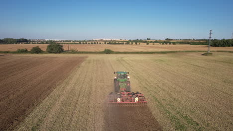 Aerial-View,-Tractor-Plowing-in-Dry-Dusty-Farming-Land-on-Sunny-Day,-Drone-Shot