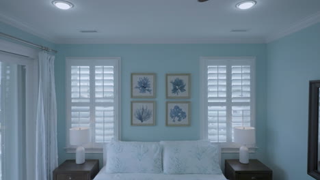 Interior-cozy-bedroom-symmetrical-shot-track-forward-towards-picture-frames