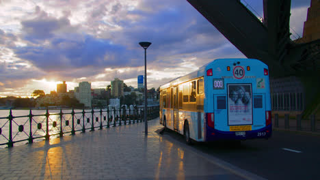 Autobús-Estacionado-En-La-Unidad-Olímpica-Bajo-El-Puente-Del-Puerto-De-Sydney-Al-Atardecer-En-Nsw,-Australia