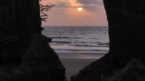 Orangefarbener-Sonnenuntergang-über-Dem-Arabischen-Meer-Mit-Blick-Zwischen-Zwei-Silhouettierten-Bäumen-In-Der-Nähe-Des-Strandes-Von-Belutschistan