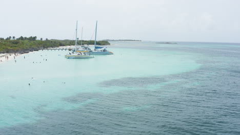 AERIAL---Catamaran-boat-on-clear-waters,-Cayo-Icacos,-Puerto-Rico,-forward-approach