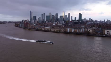 Ein-Uber-Boot-Mit-Dem-Thames-Clipper-Fährt-Am-Canary-Wharf-Auf-Der-Themse-Vorbei