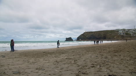 Malerische-Küstenaufnahme-Des-Strandes-Von-Portreath-Mit-Menschen-Und-Familien,-Die-An-Den-Sandstränden-Von-Cornwall-Entlang-Spazieren