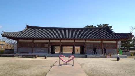 Suncheon-Bay-National-Garden-–-Paar-Spielt-In-Der-Nähe-Des-Hanok-Hauses-Das-Traditionelle-Koreanische-Spiel-Ddakji-–-Mann-Wirft-Eine-Papierkarte-über-Eine-Andere,-Um-Sie-Umzudrehen