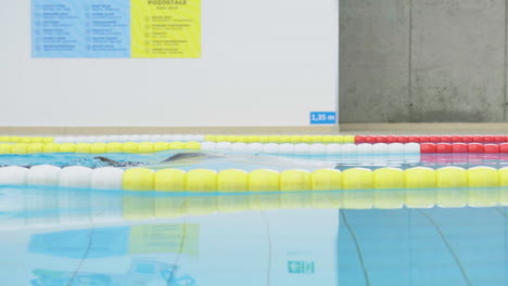 Seitenansicht-Einer-Jungen-Kaukasischen-Schwimmerin-Im-Schwimmbad,-Die-Im-Großen-Becken-Unter-Wasser-Taucht