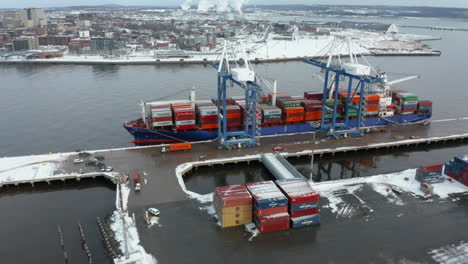 Aerial-view-of-cranes-lowering-shipping-containers-on-to-flatbed-trucks-in-the-port-of-Saint-John,-New-Brunswick