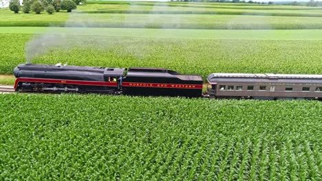 An-Aerial-Parallel-View-of-an-Antique-Steam-Passenger-Train-Traveling-With-Black-Smoke-Thru-Farmlands