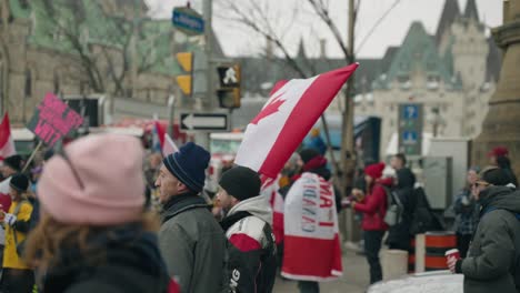 Manifestantes-Con-Banderas-Canadienses-Se-Paran-Con-El-Convoy-De-Libertad-De-Camioneros-En-Ottawa,-Canadá