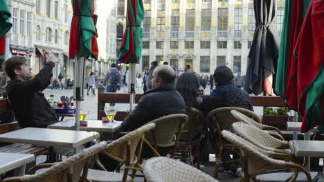 Padre-E-Hijo-Sentados-En-La-Terraza-De-La-Gran-Plaza-De-Bruselas,-Bélgica