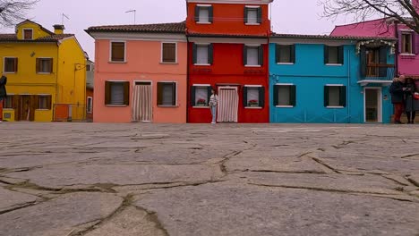 Man-taking-picture-to-posing-woman-in-Burano-town-of-Venice-lagoon-in-Italy