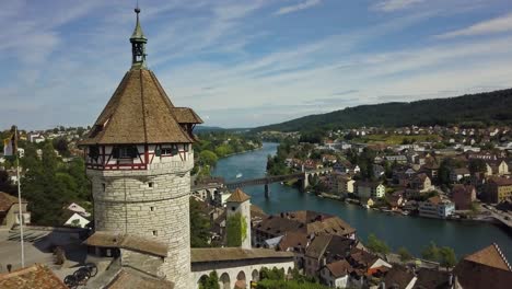 Aerial-dolly-in-of-Munot-circular-fortress-on-a-hill-revealing-Schaffhausen-village-and-High-Rhine-river,-hills-in-background,-Switzerland