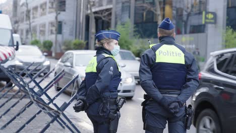 Two-Belgian-cops-controlling-road-traffic-to-prevent-freedom-convoys-entering-the-city-center-of-Brussels,-Belgium-to-block-major-roads