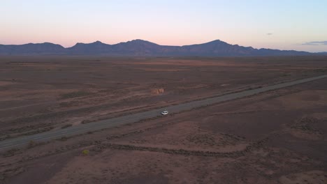 Panorama-En-órbita,-Furgoneta-Blanca-En-La-Carretera-Del-Desierto-En-Un-Paisaje-Interminable-Del-Interior