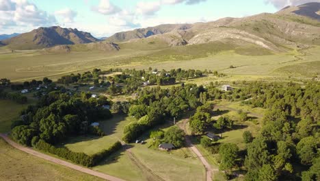 Vista-Aérea-De-Un-Pequeño-Pueblo-Con-Follaje-Verde-Y-Paisajes-Montañosos
