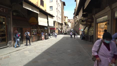 people-walking-through-The-Ponte-Vecchio-in-Florence,-it-is-a-medieval-stone-closed-spandrel-segmental-arch-bridge-in-Italy,-January-12,-2022