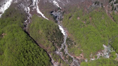 Wild-forest-and-hidden-waterfall-in-alpine-landscape