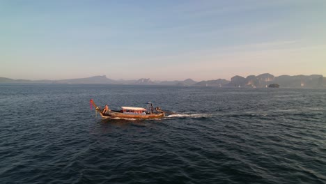 Drohnenverfolgung-Aus-Der-Luft-Parallel-Zu-Einem-Thailändischen-Longtail-Boot-Während-Einer-Sonnenaufgangstour-Mit-Einem-Touristen-An-Der-Front-In-Krabi,-Thailand