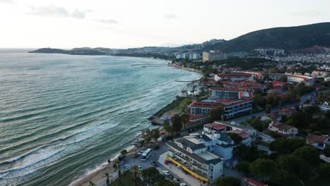 Aerial-flyover-beautiful-Turkish-coastal,-holiday-resort-town-with-hotels-and-restaurants