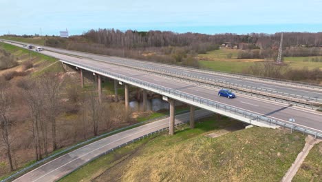 Aerila-shot,-the-highway-bridge-crosses-the-river,-cars-run-on-the-highway