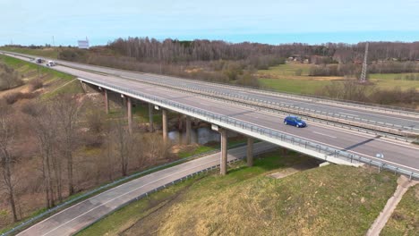 Tiro-De-Aerila,-El-Puente-De-La-Carretera-Cruza-El-Río,-Los-Autos-Corren-En-La-Carretera