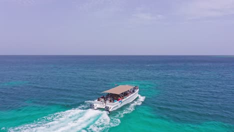 Grupo-De-Turistas-En-Lancha-Rápida-Saludando-A-La-Cámara-De-Drones-Durante-El-Viaje-En-El-Mar-Caribe