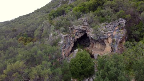 Amazing-long-aerial-view-flight-fly-backwards-drone-footage-of-a-big-cave-in-a-mountain-in-the-wild-nature-Corfu-wait-for-explorer-in-Greece-4k-Cinematic-view-from-above-by-Philipp-Marnitz-spring-2022