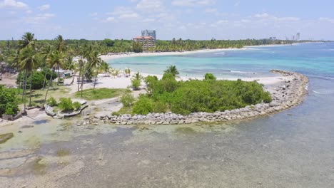 Drone-pov-of-beautiful-Juan-Dolio-beach-with-crystal-transparent-sea-water-in-Dominican-Republic