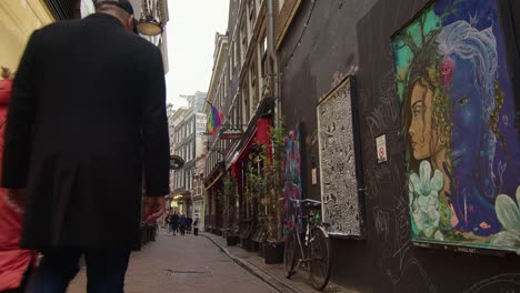 Menschen,-Die-In-Einer-Gasse-Mit-Straßenkunst-Spazieren,-Amsterdam,-Holland,-Statische-Aufnahme