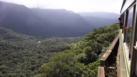 Touristen-Fotografieren-Das-Tal-Vom-Fahrenden-Zug-Im-Atlantischen-Regenwald-In-Curitiba,-Brasilien,-Während-Sie-Einen-Abgrund-überqueren