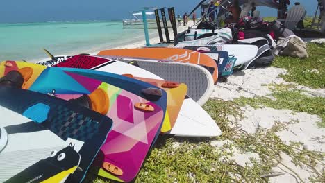 Kitesurf-equipment-on-white-sand,-grup-colorful-kiteboards-ready-to-be-used,-Los-Roques