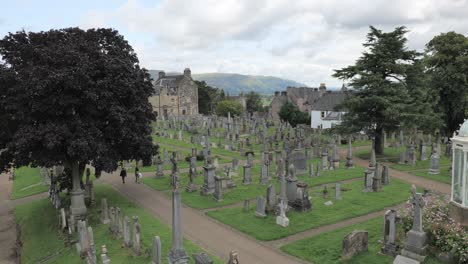 Old-Town-Cemetery-in-Stirling,-Scotland-with-tourists-and-a-large-tree