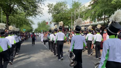 Cool-action,-Marching-Band-parade-on-Jalan-Malioboro-Yogyakarta,-and-enthusiastic-people-watching-the-parade-after-there-was-no-covid-pandemic