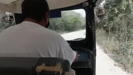 Una-Vista-Trasera-De-Un-Hombre-Vestido-Con-Una-Camiseta-Blanca-Conduciendo-Una-Bicicleta-De-Taxi-Que-Lleva-A-Los-Turistas-Por-La-Ciudad-Para-Hacer-Visitas-Turísticas-De-Compras