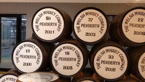 Penderyn-Whiskyfässer-Mit-Datteln-In-Der-Brennerei-In-Brecon-Beacons,-Wales,-Vereinigtes-Königreich-4K-–-Langsames-Schwenken-Von-Links-Nach-Rechts