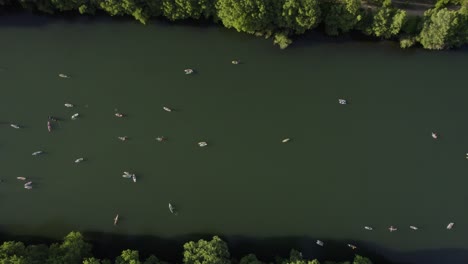 Aerial-view-of-many-SUP-boarders-on-a-river-in-Austin,-USA---overhead,-drone-shot