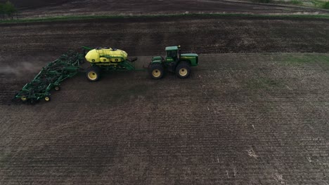 Slider-style-drone-shot-left-to-right-of-John-Deere-Tractor-seeding-field