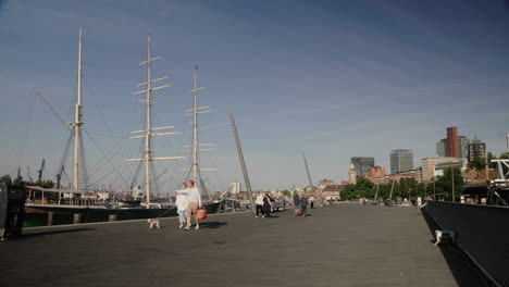 Tourists-walking-at-Hamburg-Harbor-with-Rickmer-Rickmers-in-the-back-at-river-elbe