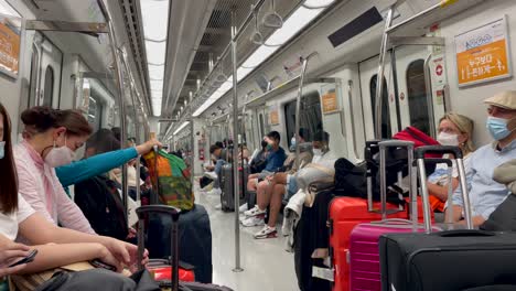 Static-shot-showing-many-people-with-face-mask-at-modern-metro-in-Seoul---Tourist-with-luggage-and-baggage-travelling-during-covid-19-pandemic