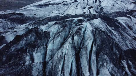 Cámara-De-Tiro-Con-Drones-Inclinándose-Hacia-Abajo-Sobre-El-Glaciar-Solheimajokull,-Islandia-En-4k