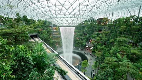 The-world's-tallest-indoor-waterfall,-the-Rain-Vortex,-surrounded-by-a-terraced-forest-setting