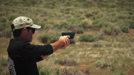 A-male-gunman-with-a-baseball-cap-fires-a-handgun-at-targets-in-120fps-slow-motion